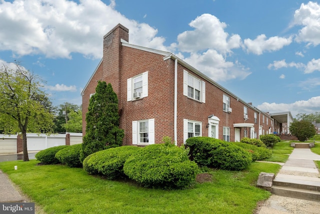 200 Maplewood Dr Unit 20, Pottstown, PA 19464 - view of home's exterior with a chimney, brick siding, a lawn, and cooling unit