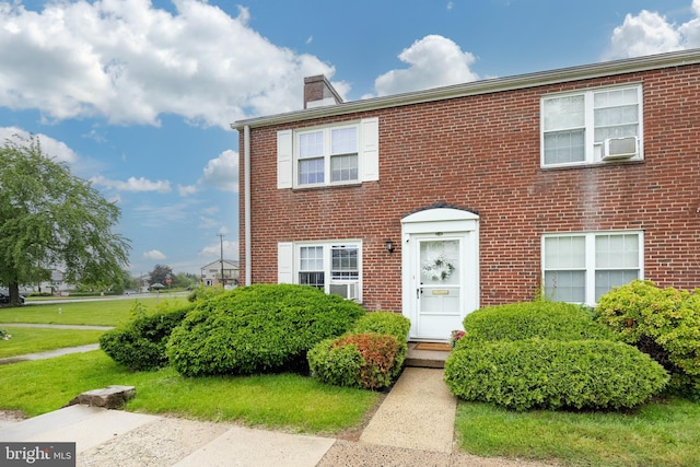 200 Maplewood Dr Unit 20, Pottstown, PA 19464 - view of front of property featuring a chimney, brick siding, cooling unit, and a front yard
