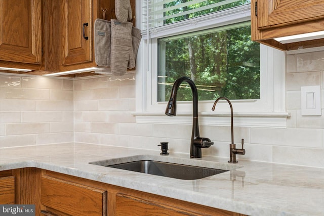 8 Crestwood Dr, Hamilton, NJ 08690 - kitchen featuring a sink, brown cabinets, backsplash, and light stone countertops