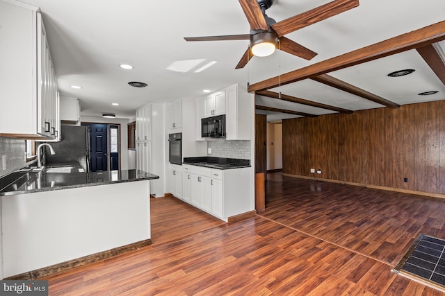 18000 Davis Ln, Boonsboro, MD 21713 - kitchen with black appliances, decorative backsplash, a ceiling fan, white cabinets, and wood walls