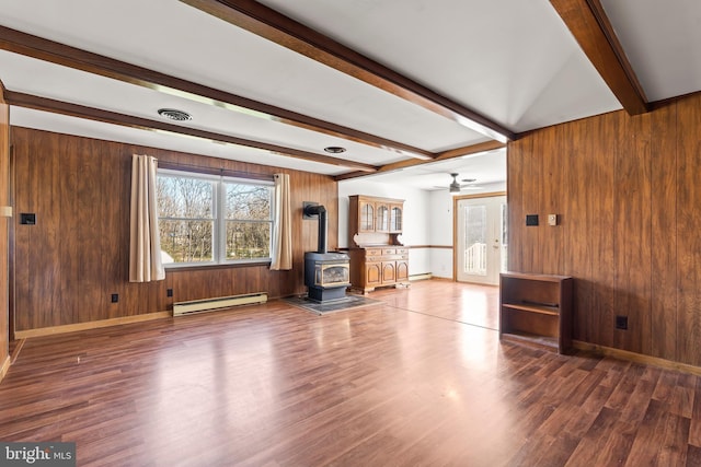 18000 Davis Ln, Boonsboro, MD 21713 - unfurnished living room with a baseboard radiator, beam ceiling, a wood stove, wood finished floors, and wooden walls