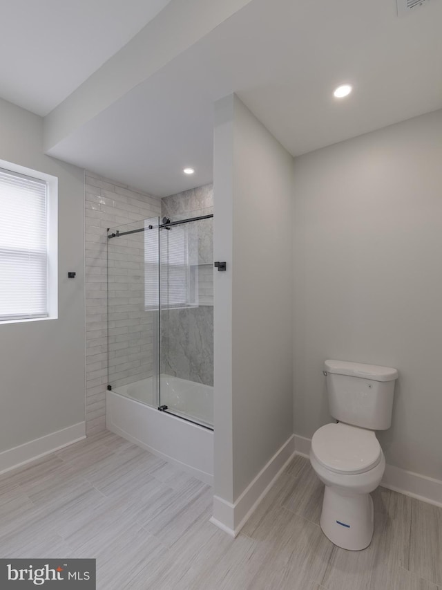 bathroom featuring baseboards, toilet, enclosed tub / shower combo, wood finished floors, and recessed lighting