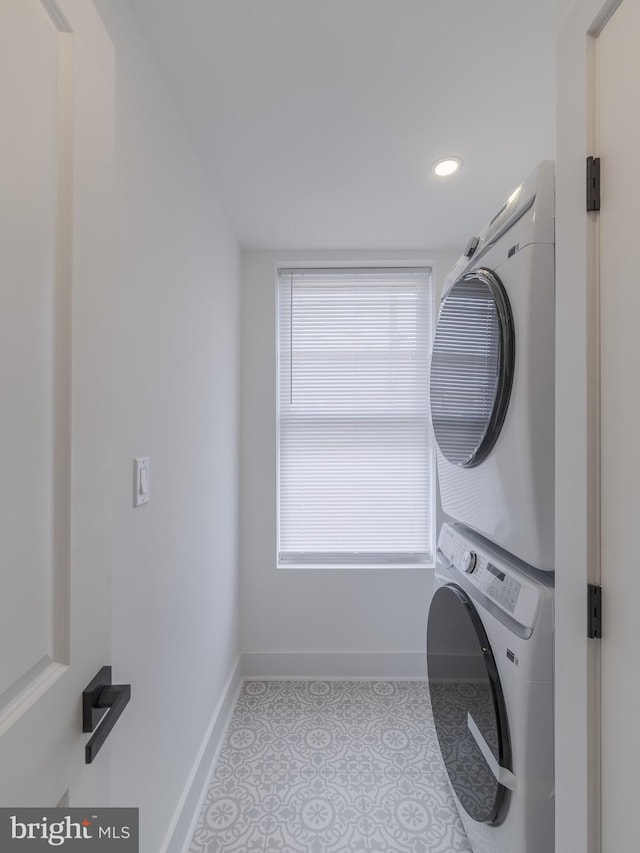 laundry area with stacked washer and clothes dryer, baseboards, recessed lighting, and tile patterned floors