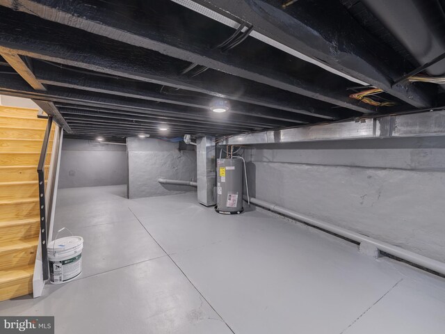 unfinished below grade area with water heater, stairway, and heating unit