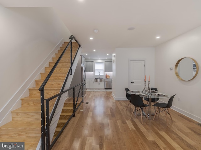 dining area featuring stairs, recessed lighting, light wood-style floors, and baseboards