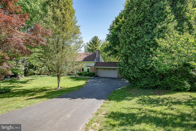 5330 Birney Hwy, Aston, PA 19014 - obstructed view of property with asphalt driveway, a front lawn, a chimney, brick siding, and a garage