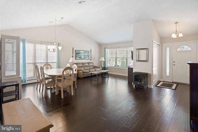 53 Stockport Dr, Toms River, NJ 08757 - dining area featuring a chandelier, lofted ceiling, dark wood-style floors, a wood stove, and baseboards