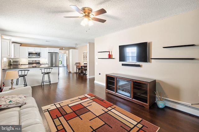 53 Stockport Dr, Toms River, NJ 08757 - living room featuring a textured ceiling, a ceiling fan, dark wood-style floors, and baseboards