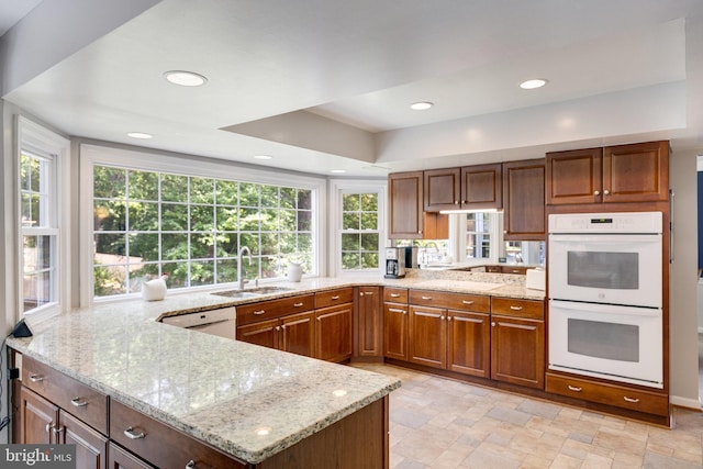 8314 Graceway Dr, Lorton, VA 22079 - kitchen featuring white appliances, a sink, light stone counters, a peninsula, and stone finish flooring