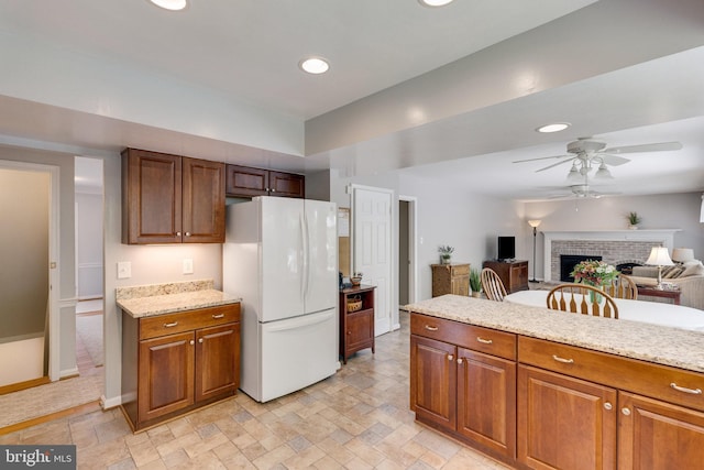 8314 Graceway Dr, Lorton, VA 22079 - kitchen featuring freestanding refrigerator, ceiling fan, a fireplace, recessed lighting, and brown cabinets