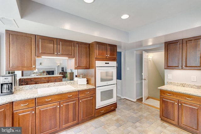 8314 Graceway Dr, Lorton, VA 22079 - kitchen with white appliances, brown cabinets, stone finish floors, light stone counters, and baseboards
