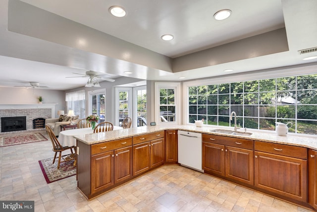 8314 Graceway Dr, Lorton, VA 22079 - kitchen with white dishwasher, a sink, a brick fireplace, healthy amount of natural light, and recessed lighting