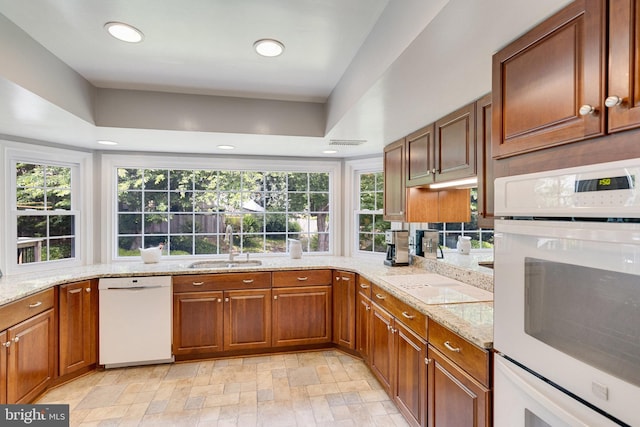 8314 Graceway Dr, Lorton, VA 22079 - kitchen featuring white appliances, a sink, recessed lighting, brown cabinets, and light stone counters