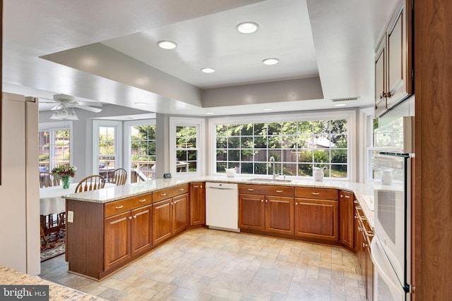 8314 Graceway Dr, Lorton, VA 22079 - kitchen featuring white appliances, a sink, light stone countertops, brown cabinetry, and recessed lighting