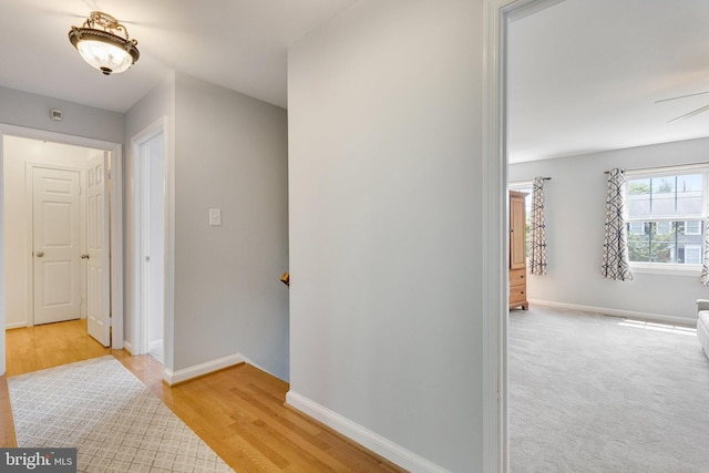 8314 Graceway Dr, Lorton, VA 22079 - corridor with baseboards, light wood-type flooring, and an upstairs landing