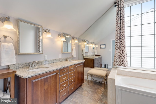 8314 Graceway Dr, Lorton, VA 22079 - bathroom featuring double vanity, a garden tub, vaulted ceiling, and stone finish floors