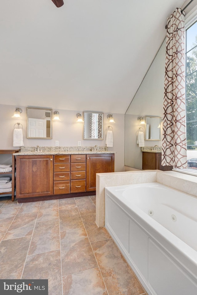 8314 Graceway Dr, Lorton, VA 22079 - bathroom featuring double vanity, a whirlpool tub, and stone finish flooring