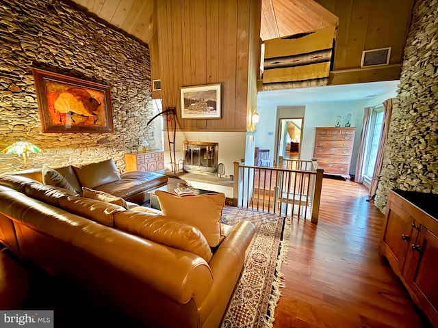 615 Westbourne Rd, West Chester, PA 19382 - living area with a glass covered fireplace, wood finished floors, a high ceiling, and wooden walls