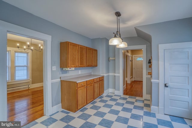 12 W Mispillion St, Harrington, DE 19952 - kitchen featuring a chandelier, light countertops, brown cabinetry, hanging light fixtures, and baseboards