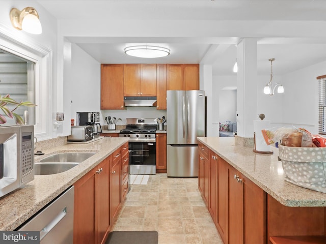 3912 13th St S, Arlington, VA 22204 - kitchen featuring stainless steel appliances, under cabinet range hood, brown cabinetry, stone finish floors, and light stone counters