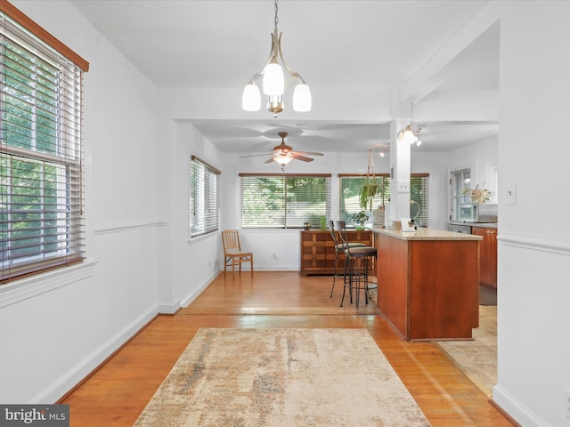 3912 13th St S, Arlington, VA 22204 - kitchen with light wood finished floors, ceiling fan, a breakfast bar area, decorative light fixtures, and stainless steel microwave