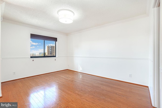 5904 Mount Eagle Dr Unit 1105, Alexandria, VA 22303 - spare room featuring crown molding, a textured ceiling, wood finished floors, and baseboards