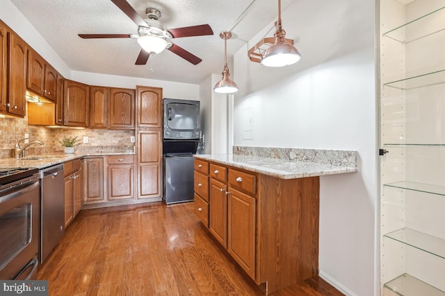 5904 Mount Eagle Dr Unit 1105, Alexandria, VA 22303 - kitchen with estacked washer and dryer, a sink, stainless steel appliances, wood finished floors, and a textured ceiling
