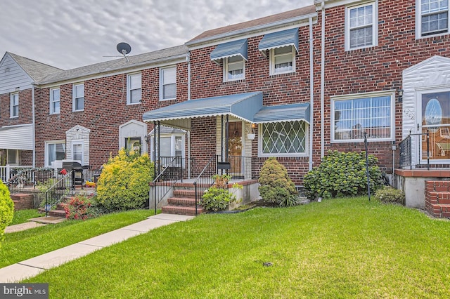 1210 Delbert Ave, Baltimore, MD 21222 - townhome / multi-family property featuring a front lawn and brick siding