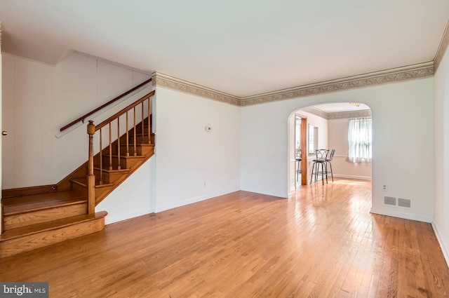 1210 Delbert Ave, Baltimore, MD 21222 - unfurnished living room featuring arched walkways, wood finished floors, stairs, ornamental molding, and baseboards