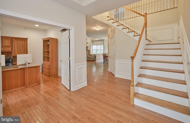 2056 Derbyshire Rd, Furlong, PA 18925 - kitchen featuring light wood-style flooring, brown cabinets, a decorative wall, wainscoting, and light countertops