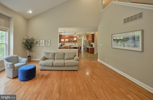 2056 Derbyshire Rd, Furlong, PA 18925 - living room featuring baseboards, high vaulted ceiling, and light wood-style flooring