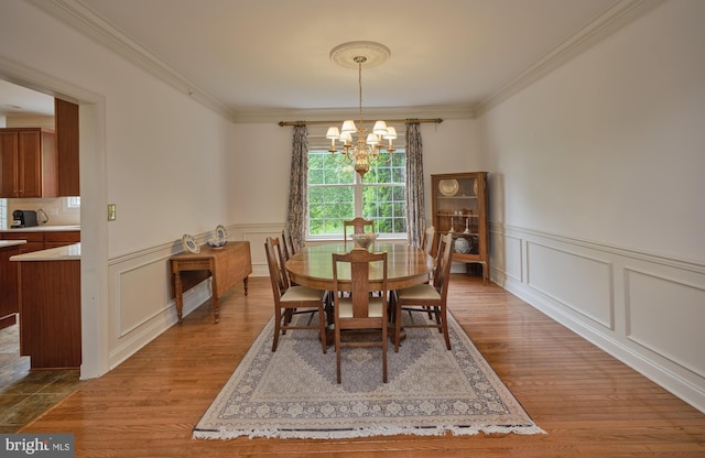 2056 Derbyshire Rd, Furlong, PA 18925 - dining space with a chandelier, crown molding, wood finished floors, a decorative wall, and a wainscoted wall