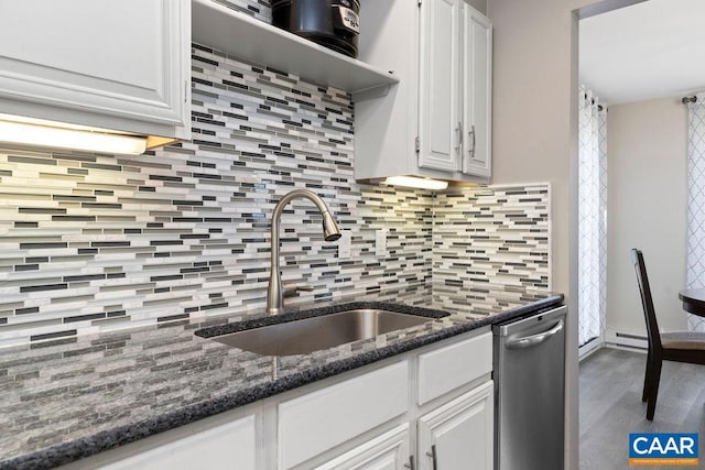 2070 Stone Rdg, Condos, Wintergreen, VA 22967 - kitchen featuring stainless steel dishwasher, a sink, white cabinets, backsplash, and wood finished floors