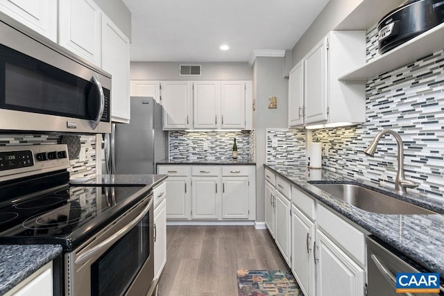 2070 Stone Rdg, Condos, Wintergreen, VA 22967 - kitchen with appliances with stainless steel finishes, white cabinets, wood finished floors, a sink, and recessed lighting