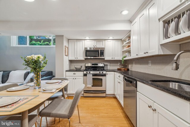 403 S Alder St, Philadelphia, PA 19147 - kitchen featuring stainless steel appliances, a sink, open shelves, white cabinets, and light wood-style floors