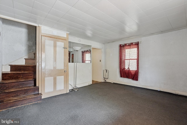 carpeted spare room with stairway