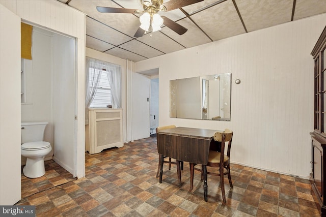 dining area featuring stone finish floors and ceiling fan