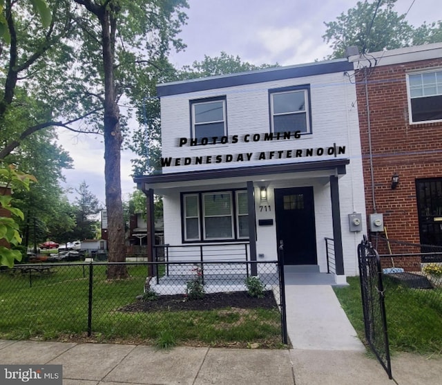 711 57th Pl NE, Washington, DC 20019 - townhome / multi-family property featuring covered porch and brick siding