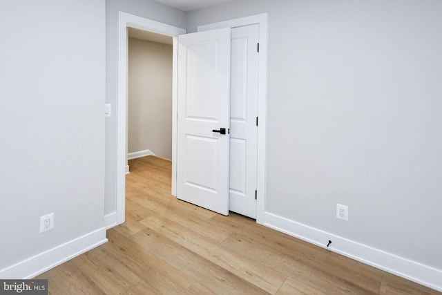 711 57th Pl NE, Washington, DC 20019 - unfurnished bedroom with light wood finished floors, baseboards, and a closet