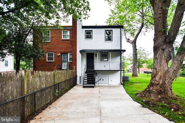 711 57th Pl NE, Washington, DC 20019 - view of front of home with a chimney, covered porch, brick siding, and central AC unit