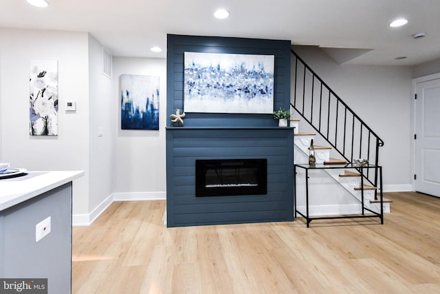 711 57th Pl NE, Washington, DC 20019 - unfurnished living room with wood finished floors, stairs, recessed lighting, baseboards, and a fireplace