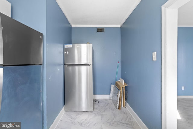 kitchen with freestanding refrigerator, crown molding, and baseboards