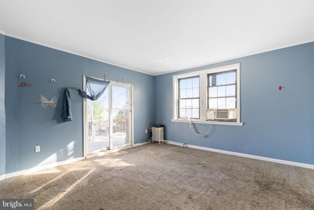 spare room featuring baseboards, carpet floors, crown molding, and cooling unit