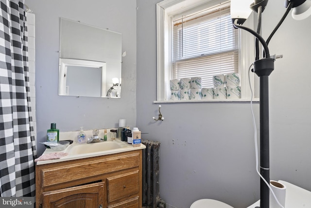 bathroom featuring radiator, vanity, toilet, and a shower with curtain