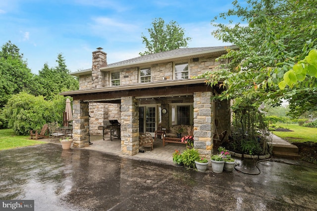 1 Locust Ln, Media, PA 19063 - rear view of house with stone siding, a patio, and a chimney