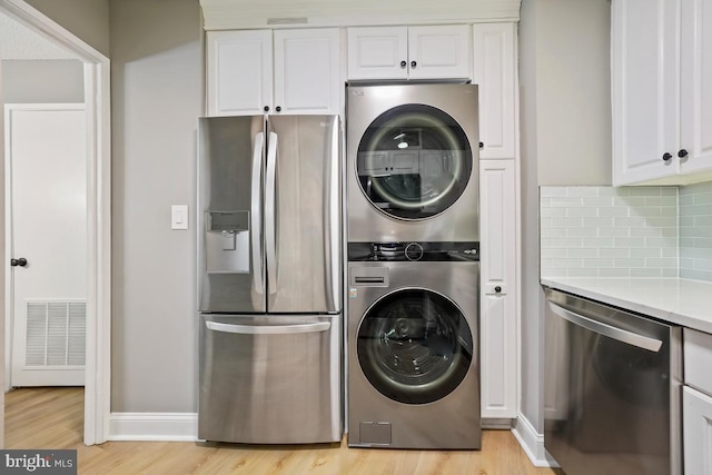 5904 Mount Eagle Dr Unit 1003, Alexandria, VA 22303 - laundry area featuring stacked washing machine and dryer, light wood finished floors, and baseboards