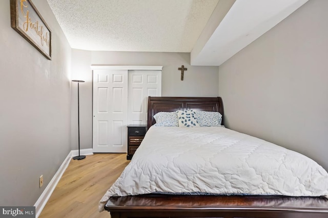 5904 Mount Eagle Dr Unit 1003, Alexandria, VA 22303 - bedroom featuring baseboards, light wood-type flooring, a textured ceiling, and a closet