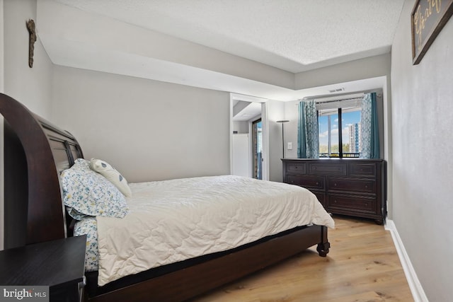 5904 Mount Eagle Dr Unit 1003, Alexandria, VA 22303 - bedroom featuring baseboards, light wood-style flooring, and a textured ceiling