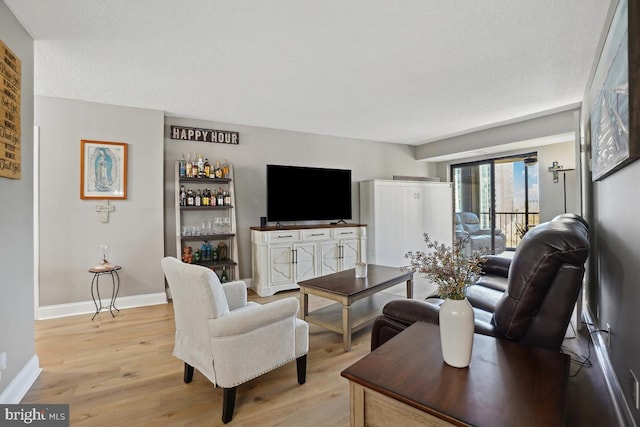 5904 Mount Eagle Dr Unit 1003, Alexandria, VA 22303 - living area with light wood finished floors, baseboards, a bar, and a textured ceiling