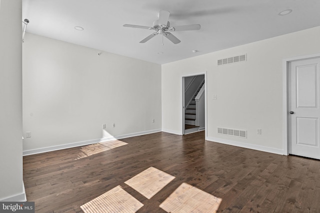 empty room with stairway, wood finished floors, ceiling fan, and baseboards
